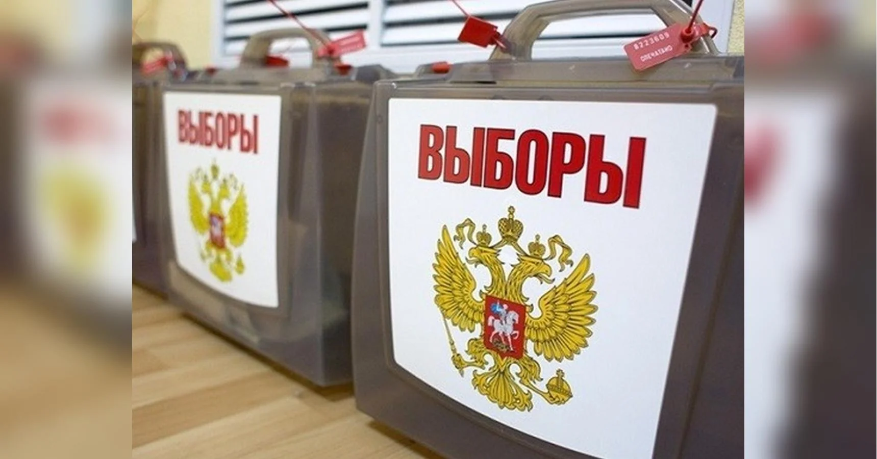 Прозорі урни для голосування з написом Вибори та гербом Росії