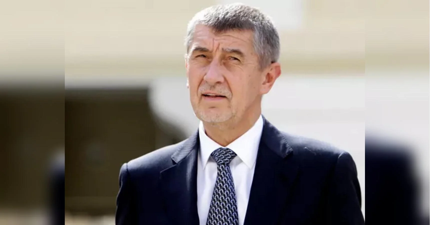Андрей Бабіш у темно-синьому костюмі та візерунчастій краватці на розмитому тлі