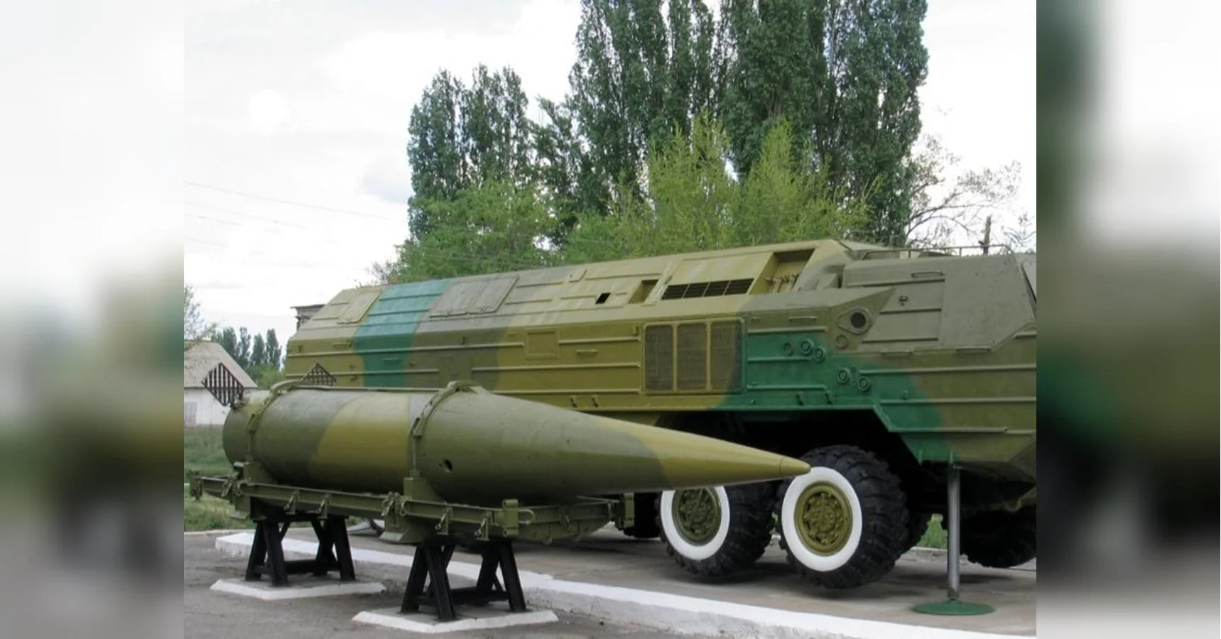 Балістична ракета на стенді біля камуфляжної колісної пускової установки