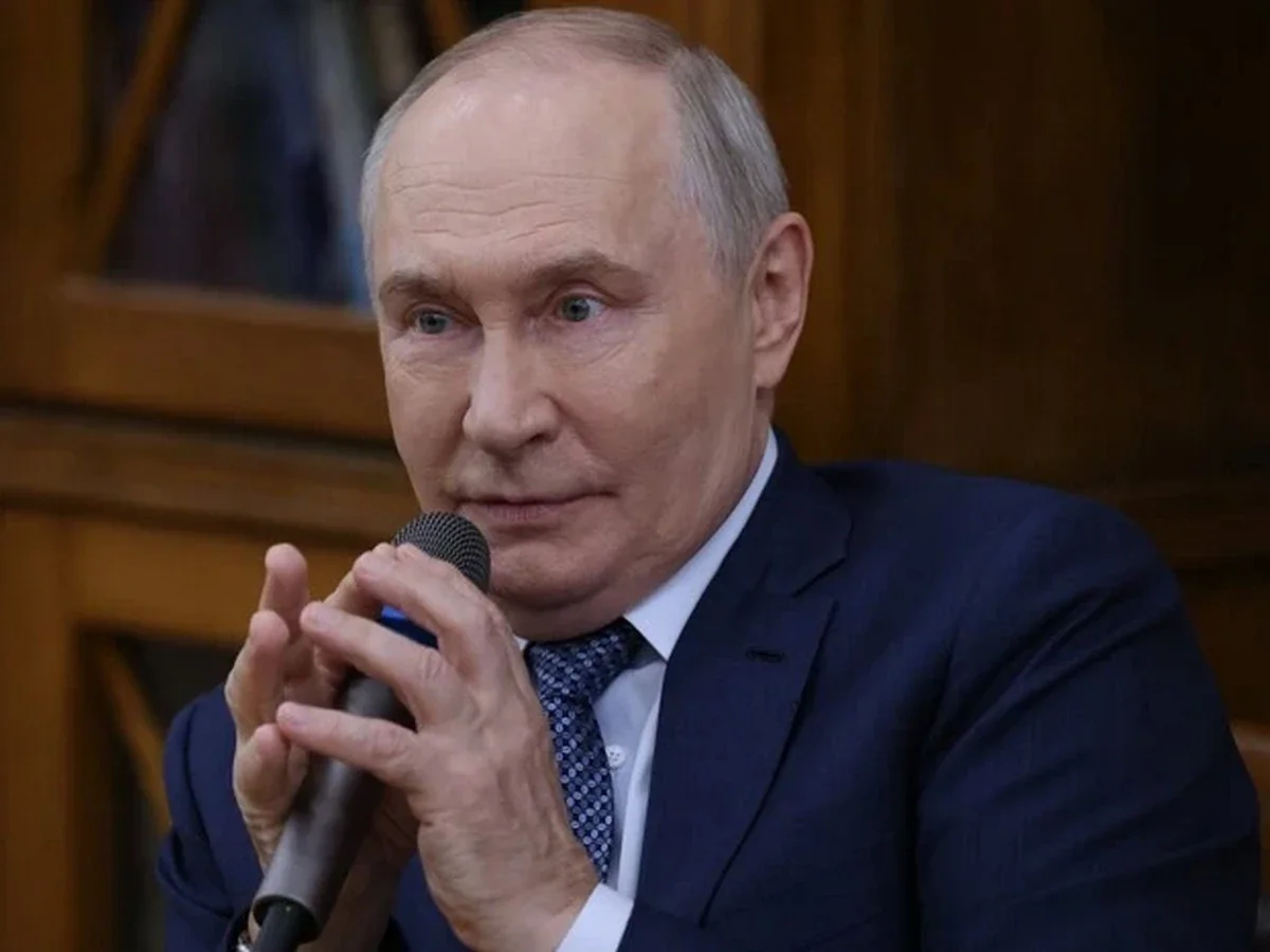 Володимир Путін говорить у мікрофон на тлі деревяної панелі