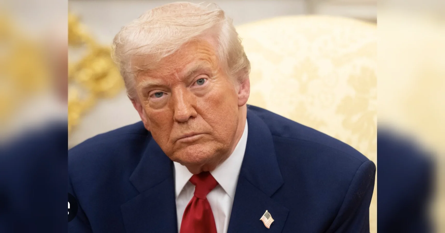 Дональд Трамп у синьому костюмі з червоною краваткою сидить у кріслі