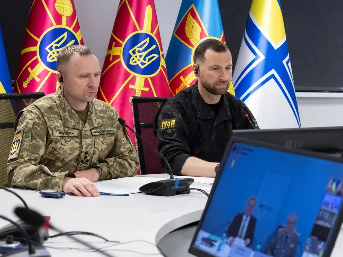 Драпатий і міністр оборони за столом на засіданні Рамштайн з прапорами
